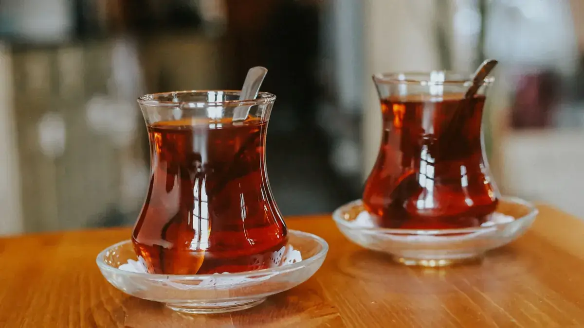 Ahşap masada yan yana duran iki ince belli çay bardağı, bir yakınla sakin bir konuşmayı simgeliyor